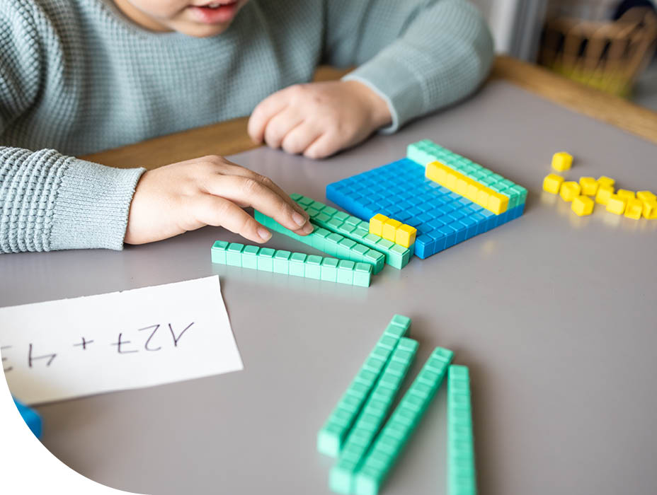 Little boy using the base 10 method to do addition at home
